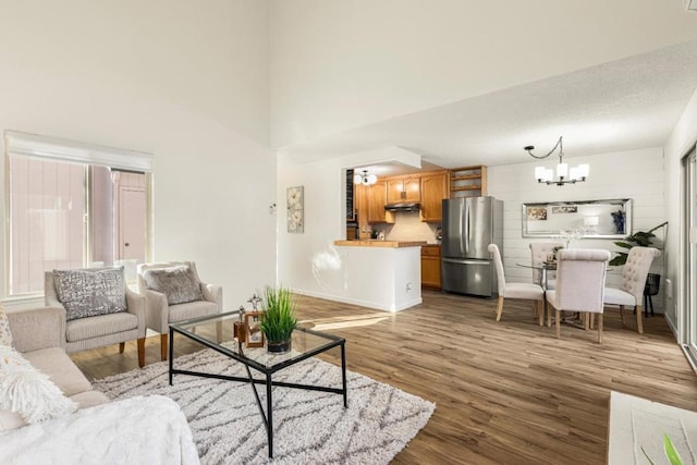 living room featuring a high ceiling, hardwood / wood-style floors, and an inviting chandelier