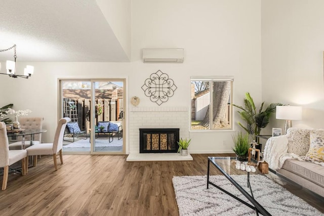 living room with hardwood / wood-style flooring, plenty of natural light, a wall mounted AC, and a brick fireplace