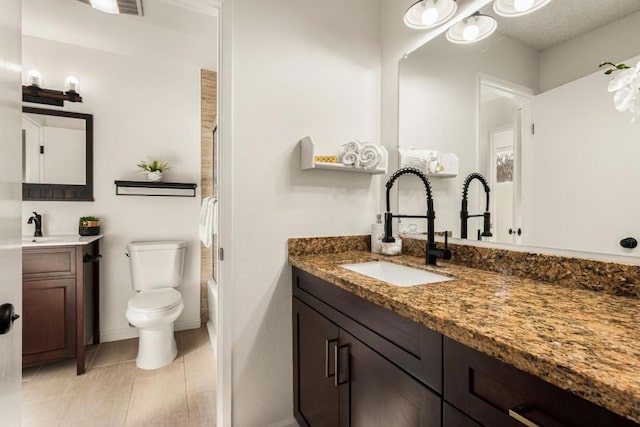 full bathroom with shower / tub combination, vanity, tile patterned flooring, and toilet