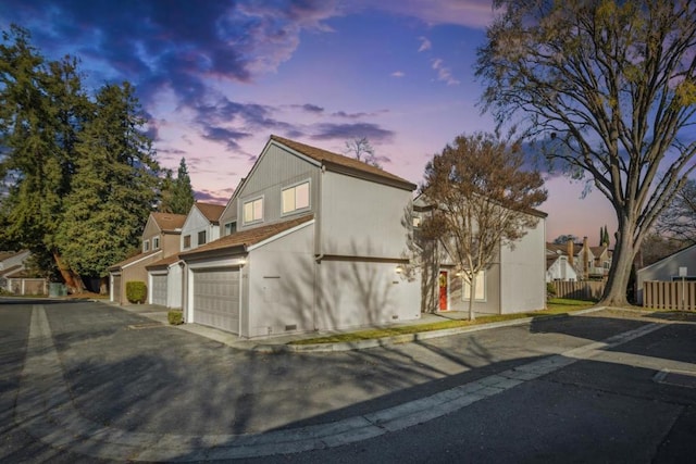 property exterior at dusk featuring a garage