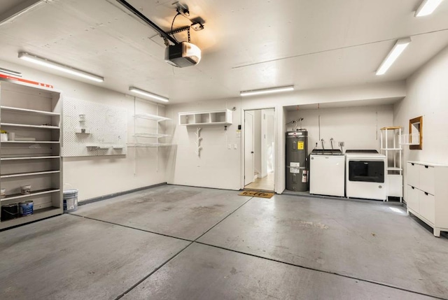 garage with a garage door opener, electric water heater, and washer and dryer