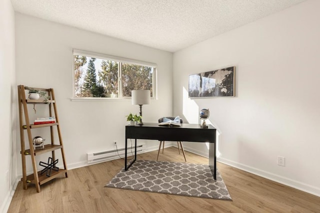 home office featuring baseboard heating, light hardwood / wood-style flooring, and a textured ceiling