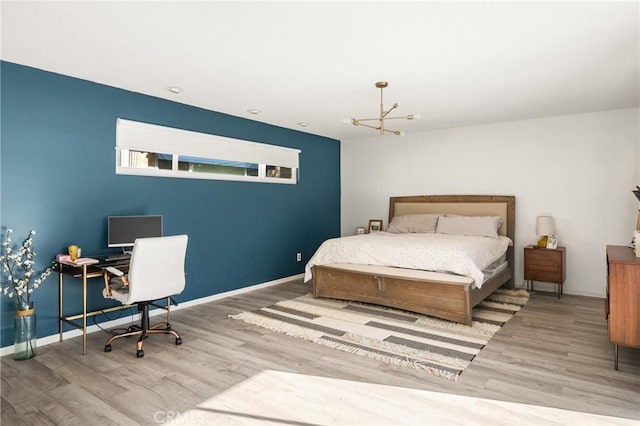 bedroom featuring a chandelier and light hardwood / wood-style flooring