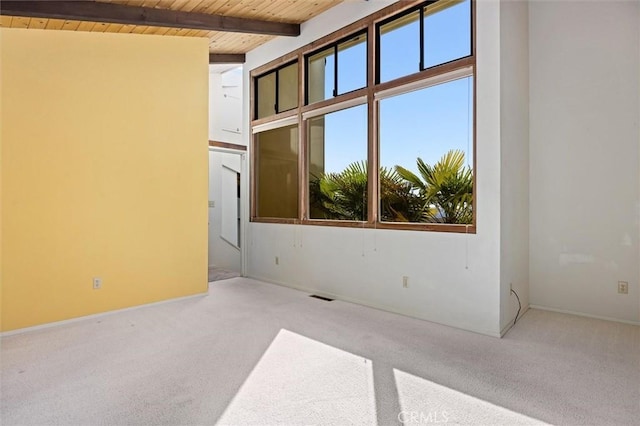 spare room with wooden ceiling, light colored carpet, and beam ceiling