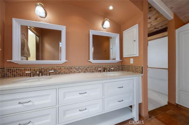 bathroom with lofted ceiling, vanity, and backsplash