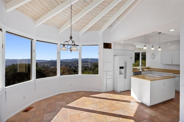 kitchen with a mountain view, decorative light fixtures, white cabinetry, and high end fridge