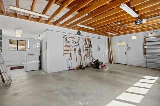 garage with a garage door opener and electric panel