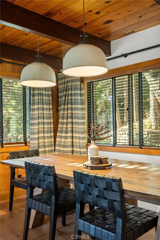 dining space featuring beam ceiling, wood-type flooring, and wood ceiling