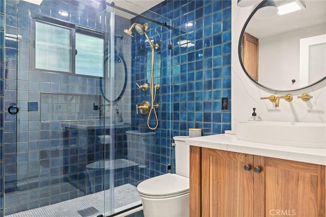 bathroom with toilet, tile walls, an enclosed shower, and vanity