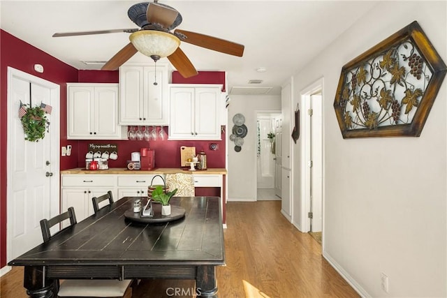 kitchen with ceiling fan, light wood-type flooring, and white cabinets