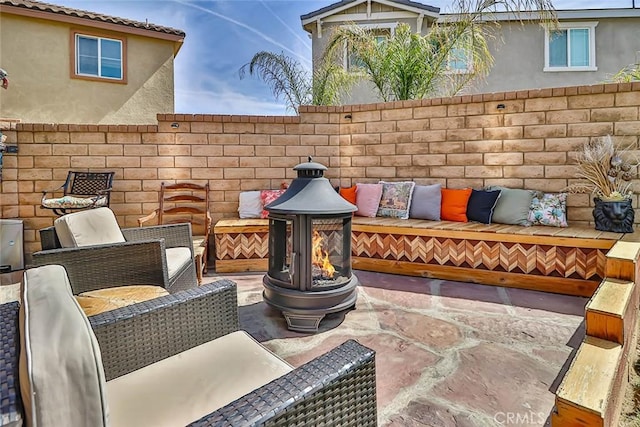 view of patio with an outdoor living space with a fire pit