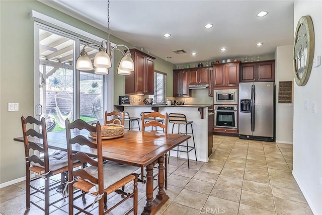 tiled dining space with a notable chandelier