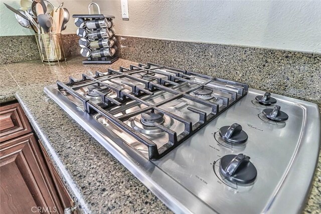 details featuring stone countertops and stainless steel gas cooktop