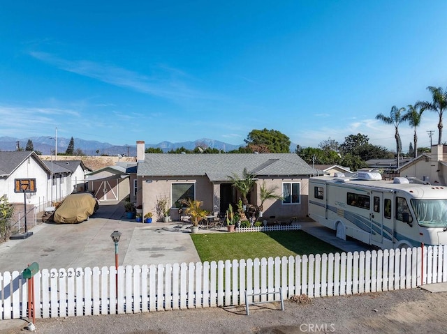 view of front of house with a mountain view and a front yard