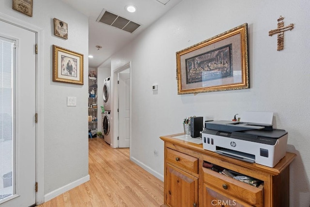 hall featuring light hardwood / wood-style floors and stacked washer and dryer