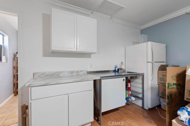 kitchen featuring white cabinetry, ornamental molding, white refrigerator, light hardwood / wood-style flooring, and sink