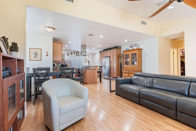 living room with ceiling fan and light wood-type flooring