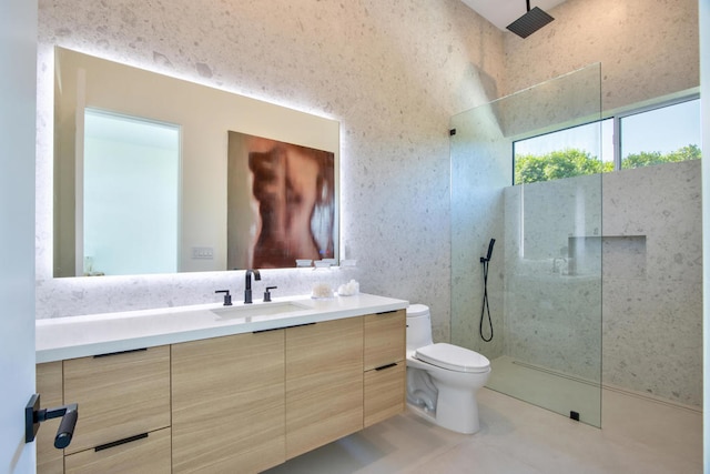 bathroom featuring toilet, a tile shower, tile patterned floors, and vanity