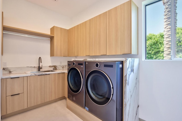 laundry area featuring cabinets, sink, and washing machine and dryer