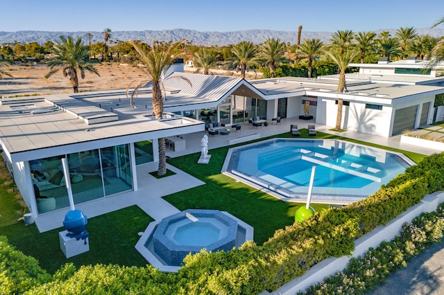 view of swimming pool with a patio area, a mountain view, and a yard