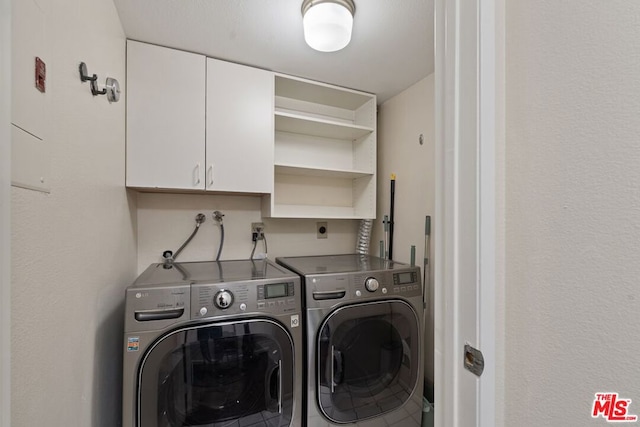 laundry room featuring washing machine and dryer and cabinets