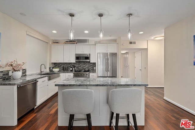 kitchen with white cabinets, sink, stainless steel appliances, and pendant lighting