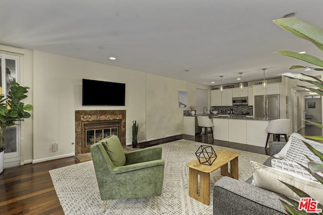 living room featuring a high end fireplace and dark hardwood / wood-style floors