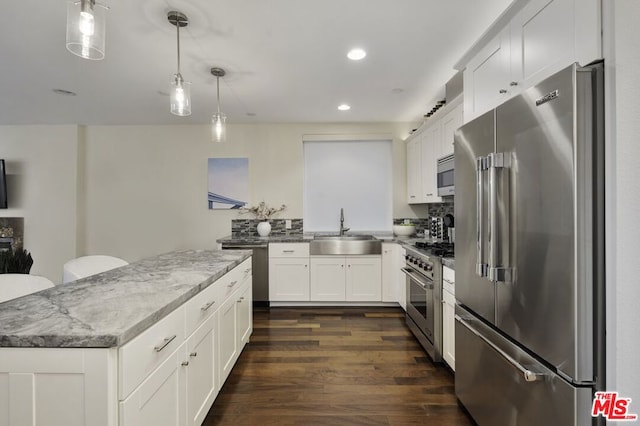 kitchen featuring decorative light fixtures, white cabinetry, dark hardwood / wood-style flooring, high end appliances, and sink