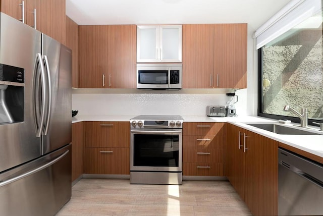 kitchen featuring light wood-type flooring, appliances with stainless steel finishes, sink, and plenty of natural light