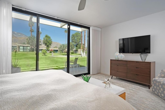 bedroom featuring ceiling fan, access to exterior, and multiple windows