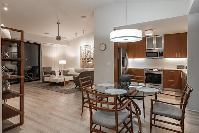 dining room featuring ceiling fan, high vaulted ceiling, and light hardwood / wood-style flooring