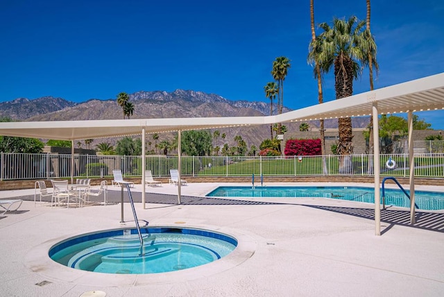 view of pool with a mountain view, a hot tub, and a patio