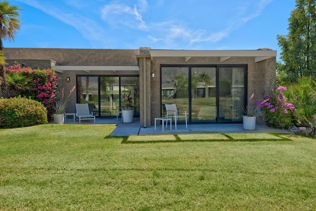 back of house featuring a lawn and a patio