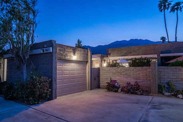 garage at dusk featuring a mountain view