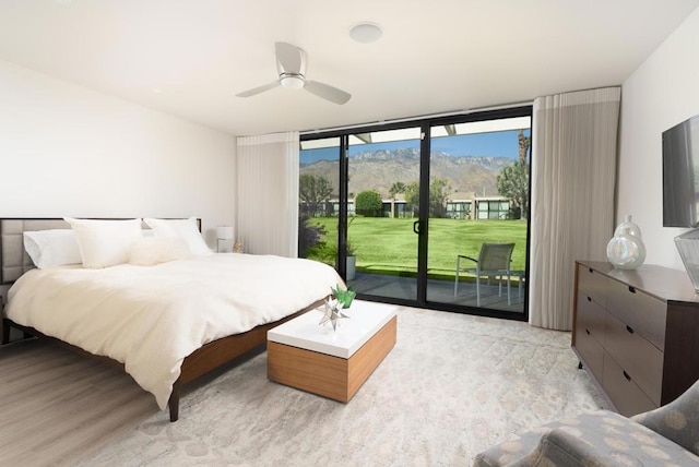 bedroom featuring access to outside, ceiling fan, floor to ceiling windows, and light hardwood / wood-style floors