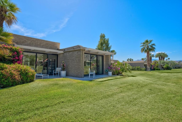 back of house with a patio area and a lawn