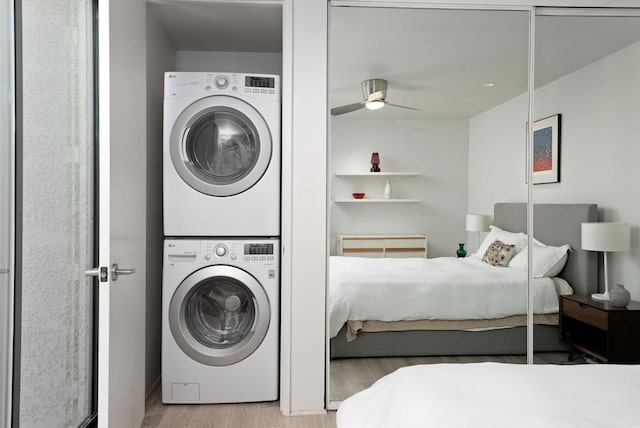 bedroom with ceiling fan, light hardwood / wood-style floors, and stacked washer / drying machine