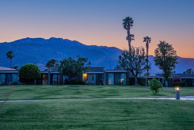 ranch-style home featuring a lawn and a mountain view