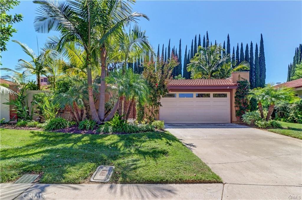 view of front of home with a garage and a front lawn