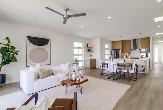 living room with ceiling fan and light hardwood / wood-style floors