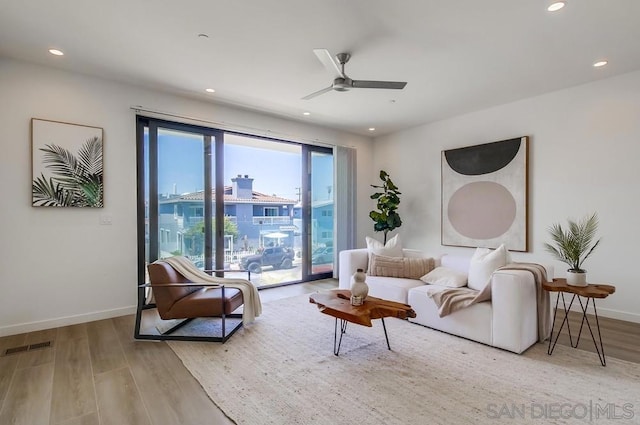 living room with ceiling fan and light hardwood / wood-style flooring