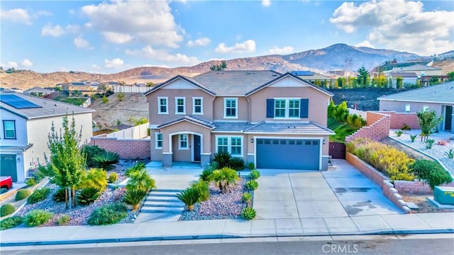 view of front of home with a mountain view and a garage