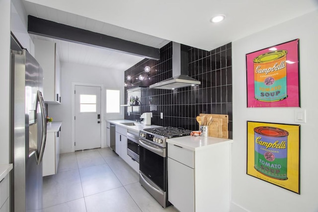 kitchen featuring white cabinets, wall chimney exhaust hood, beamed ceiling, and stainless steel appliances