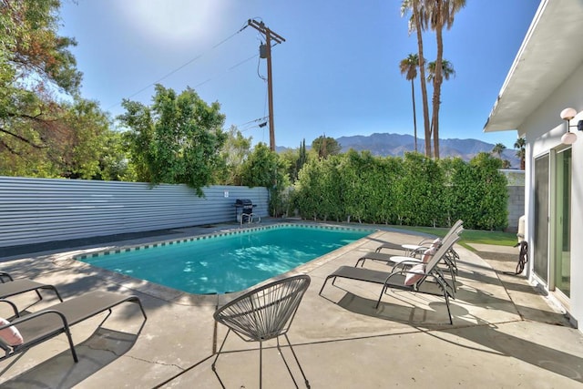 view of swimming pool featuring a mountain view and a patio