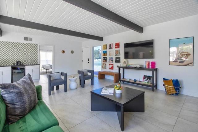 living room with beam ceiling, beverage cooler, and bar