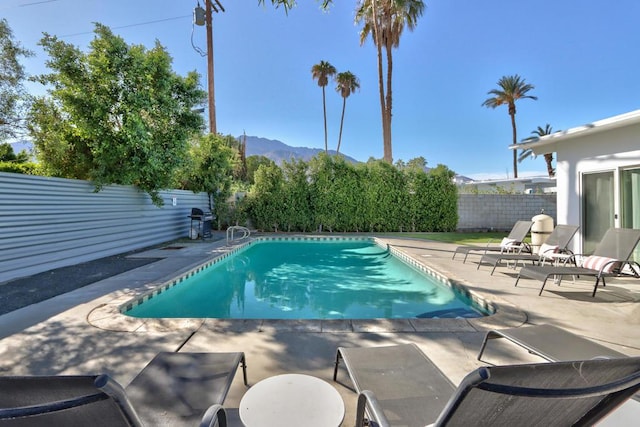 view of swimming pool featuring a mountain view and a patio area