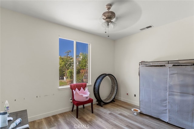 sitting room with ceiling fan and light wood-type flooring