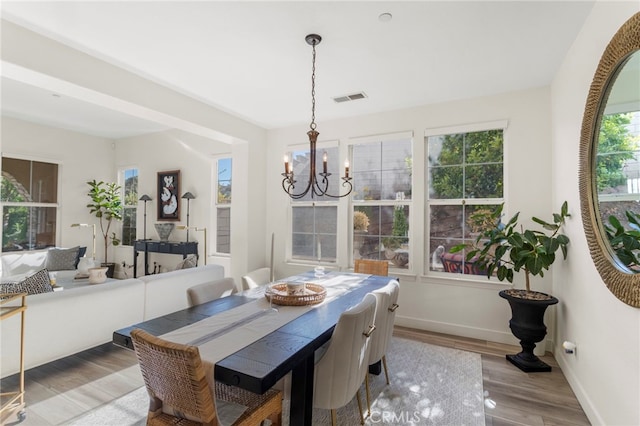 dining area featuring a healthy amount of sunlight, a chandelier, and light hardwood / wood-style floors