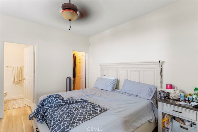 bedroom featuring ceiling fan, ensuite bathroom, and hardwood / wood-style flooring