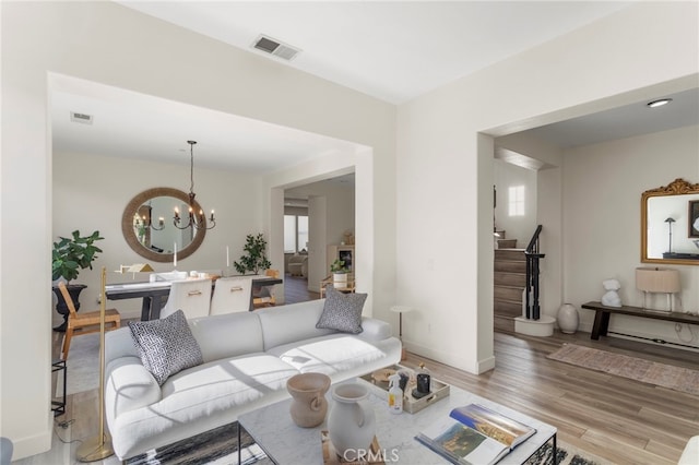 living room featuring a notable chandelier and light hardwood / wood-style floors